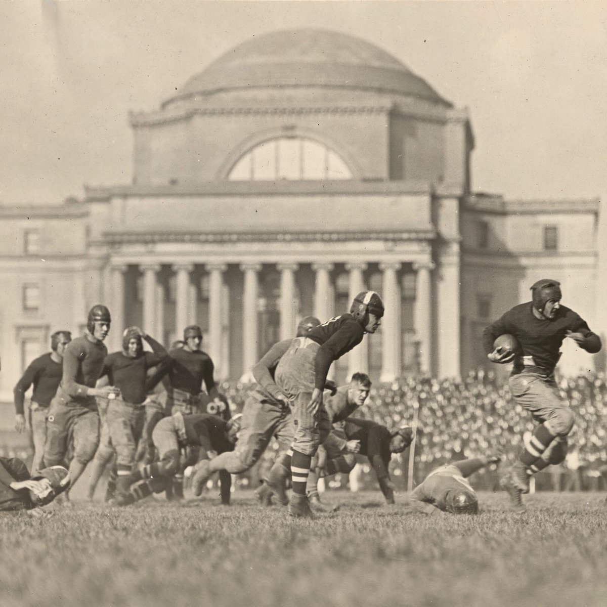 Black-and-white photo of football game in front of Low Library.