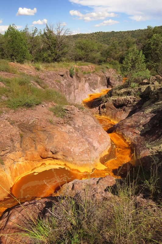 Orange, iron-rich precipitate (ochre) from outflow of Lead Queen mine tunnel, after late September 2014 monsoon storm. Photo by Glen E. "Gooch" Goodwin, Photographer - used with permission.