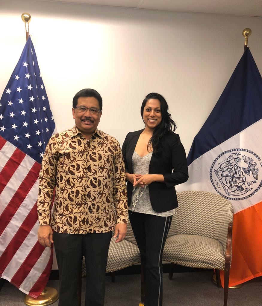 Commissioner Abeywardena and the Consul General of Indonesia stand together in front of the American and NYC flags.