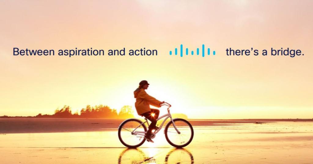 Photo of a person riding on a bike at sunset. Words: Between aspiration and action [Cisco logo] there's a bridge.