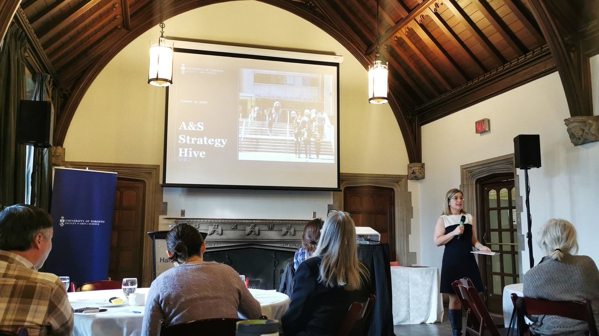 Dean Woodin speaks in front of a room with a slide reading 'A&S Strategy Hive' in the background.