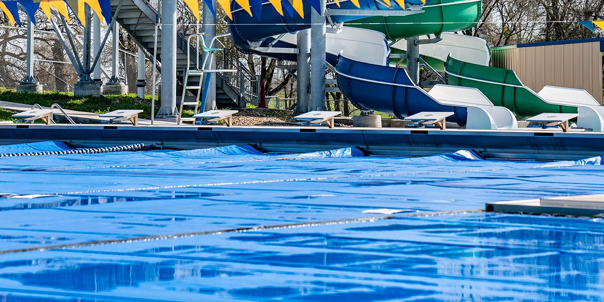 Photo of a pool with slides in the background