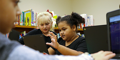 Two students play an online game together.