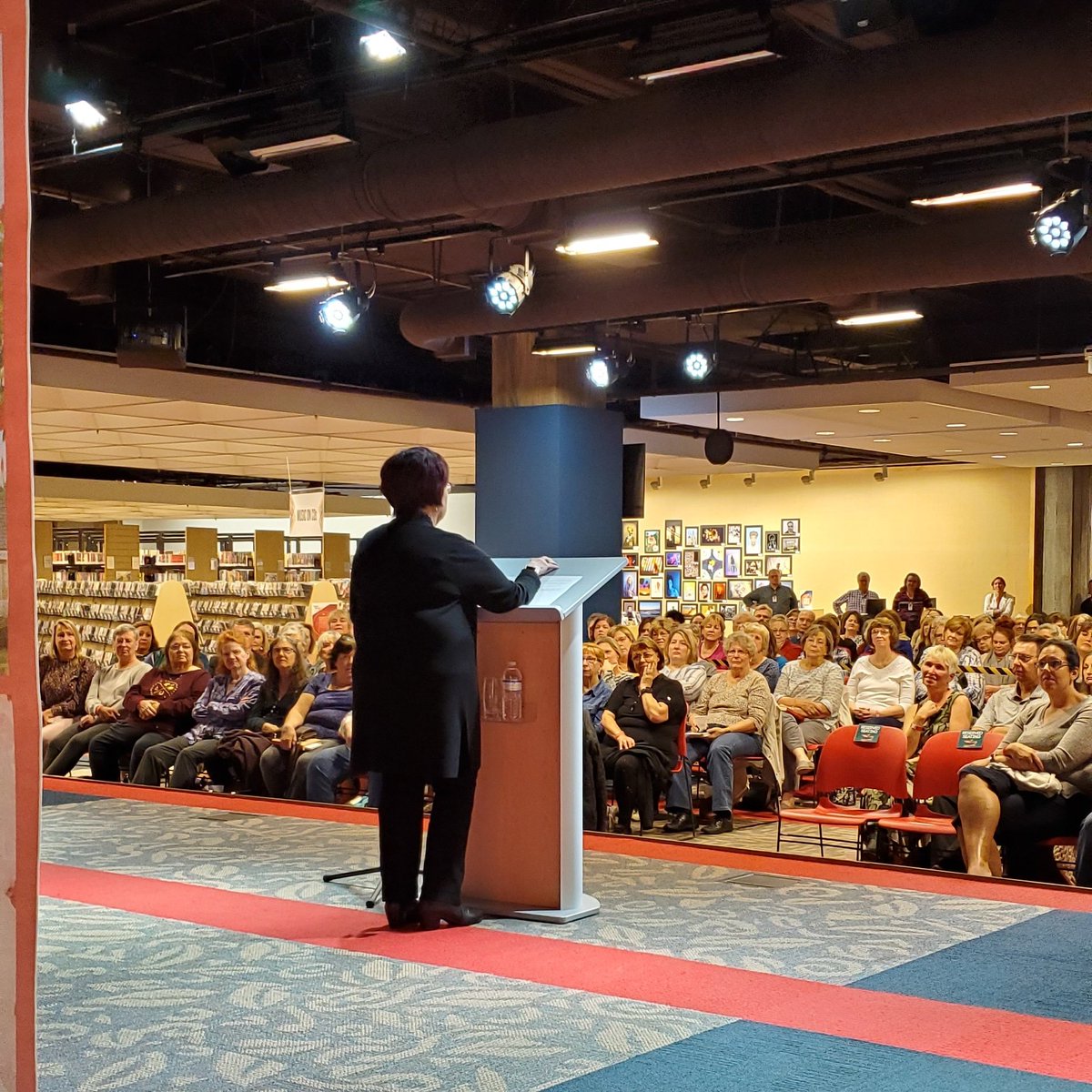 Sarah_Nicolas's tweet photo. My view from behind the curtain at the Library After Hours with @debbiemacomber!#learngrowconnect #OCLSreads #lovemyjob #librarylife #litlando https://t.co/eL7y6WSZlD
