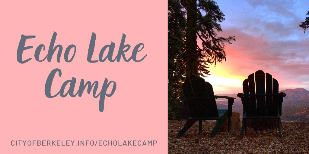 Two adirondack chairs sit in a forest, overlooking a valley. The sun is setting and the sky is full of brilliant pinks.