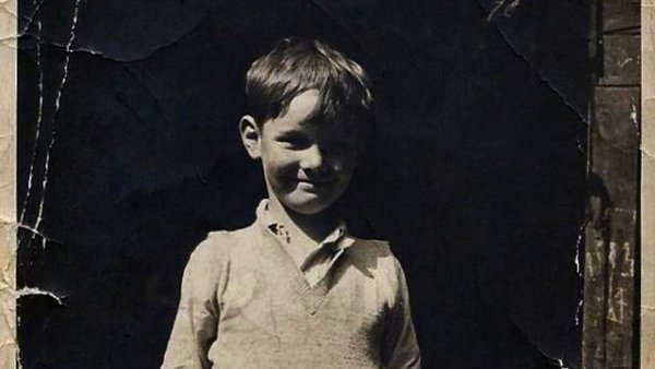 Black and white photograph of George Barker in 1937, aged 6, standing in the pub yard