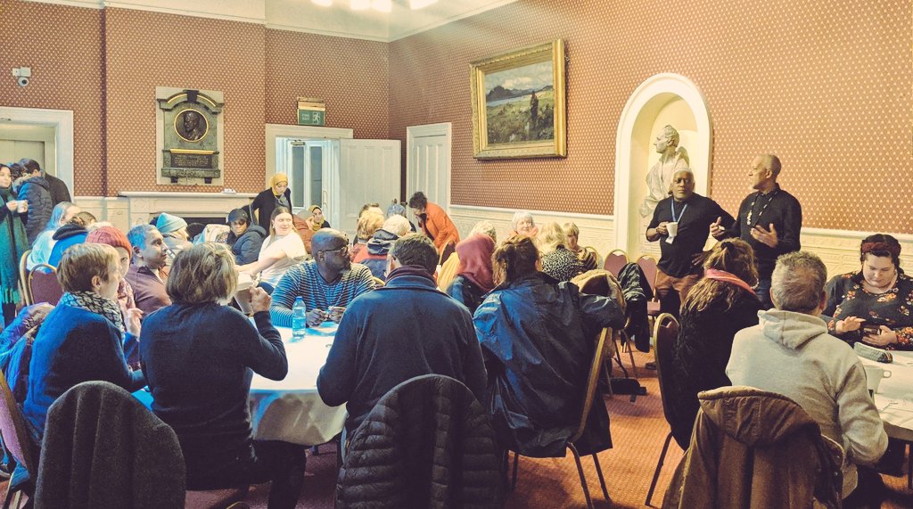 people sitting around round tables inside a room