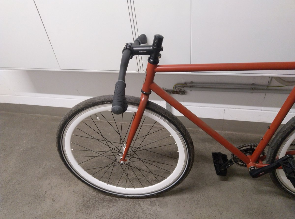 Fixie Rad mit verkehrt herum angebauter Lenkerstange, der stark nach unten geht. Von der Seite.