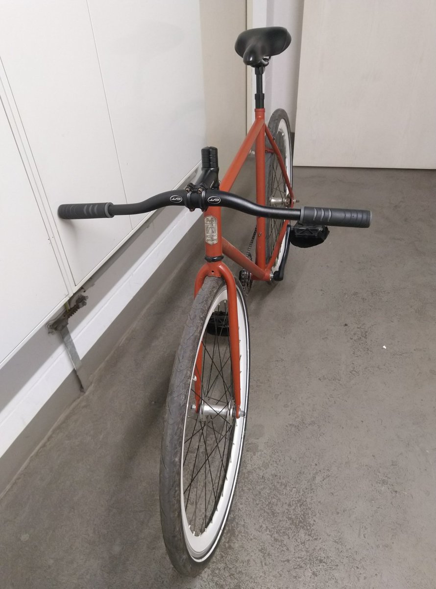 Fixie Rad mit verkehrt herum angebauter Lenkerstange, der stark nach unten geht. Von schräg vorn.