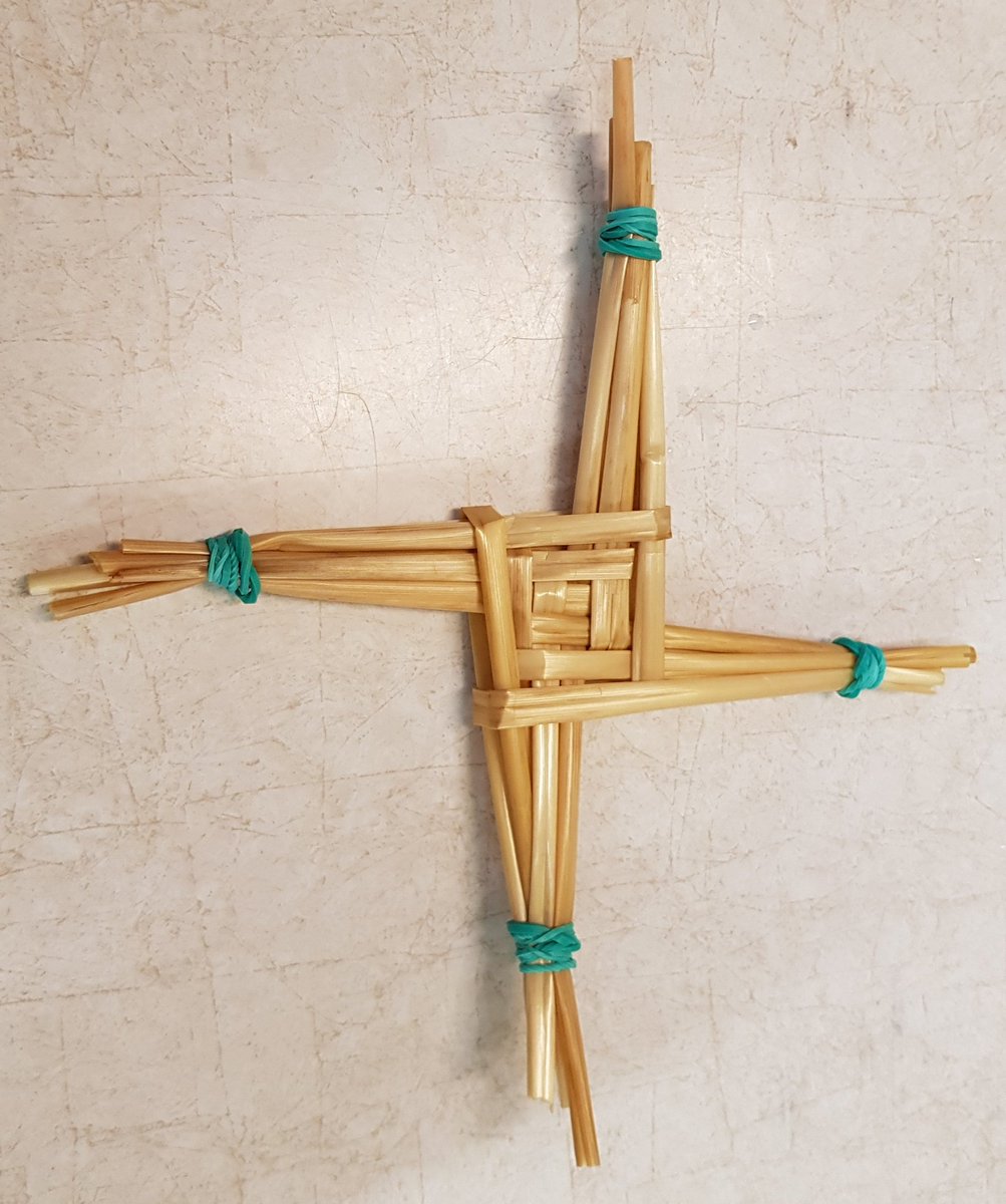 Straw folded into a St Bidget's cross, held together by 4 green elastic bands.