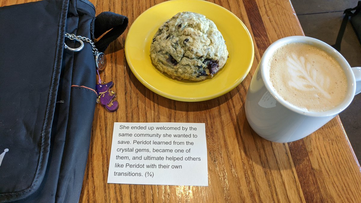 A picture of a blueberry scone, latte with latte art, bag with a witchy cat charm, and a card saying,
"She ended up welcomed by the same community she wanted to save. Peridot learned from the crystal gems, became one of them, and ultimate helped others like Peridot with their own transitions. (¾)"