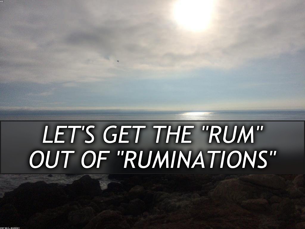 A rocky shoreline with the sun visible through the clouds