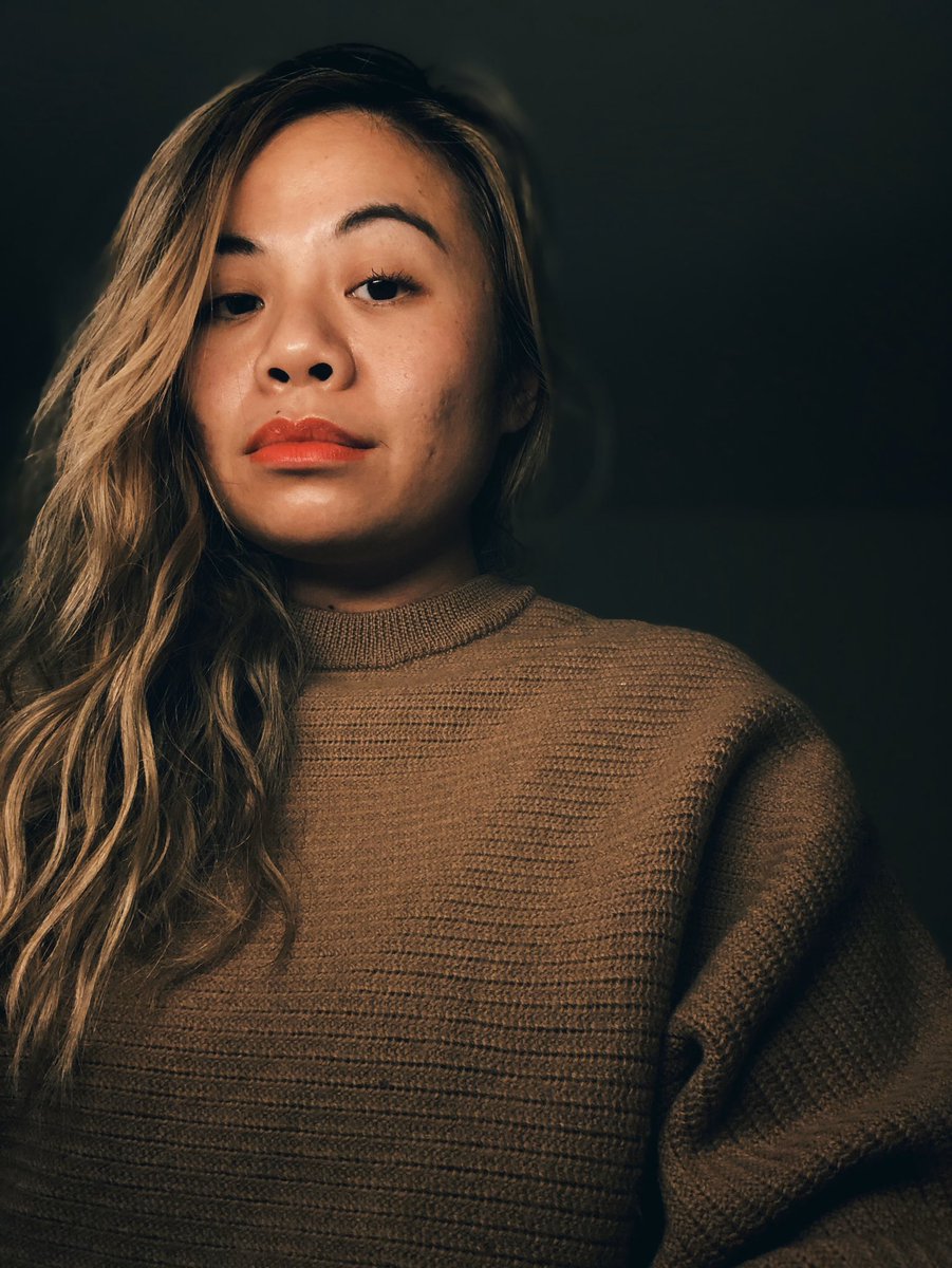 Me in a dark room with red lipstick and a wave to my hair