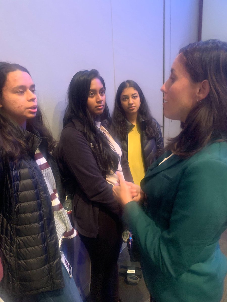Cristina speaking to a group of three voters.