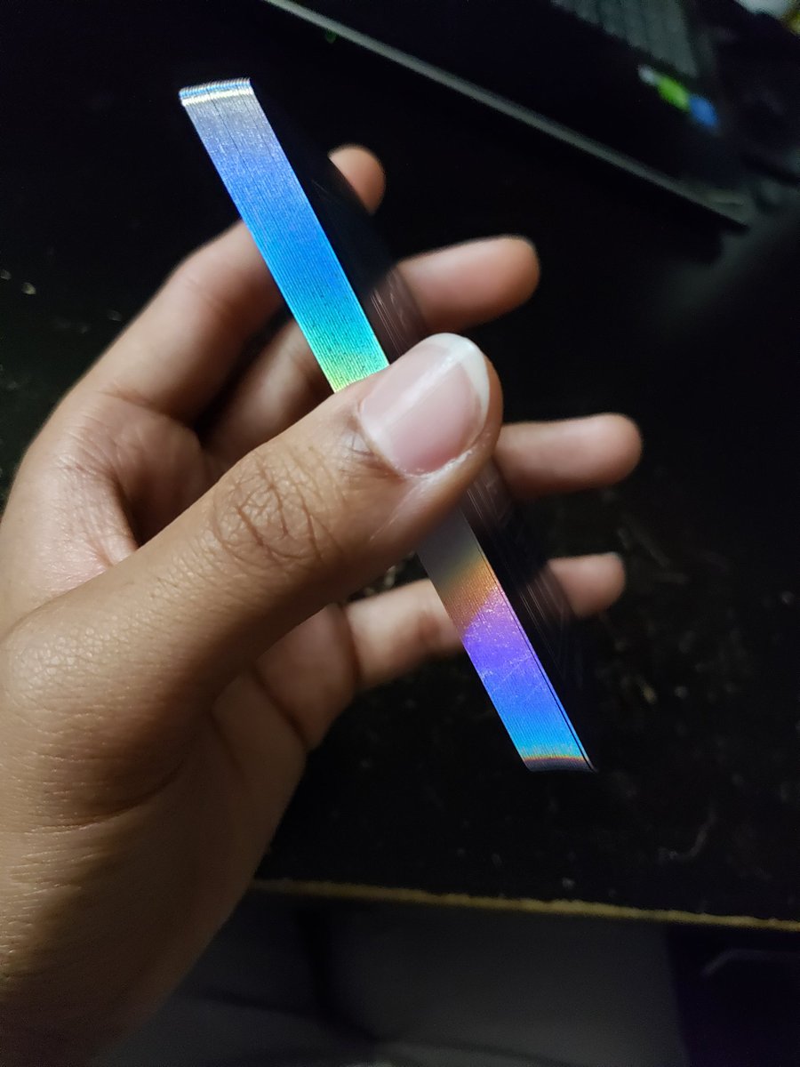 A side view of the deck of cards all stacked up showing off the edges, which have the same holographic material.