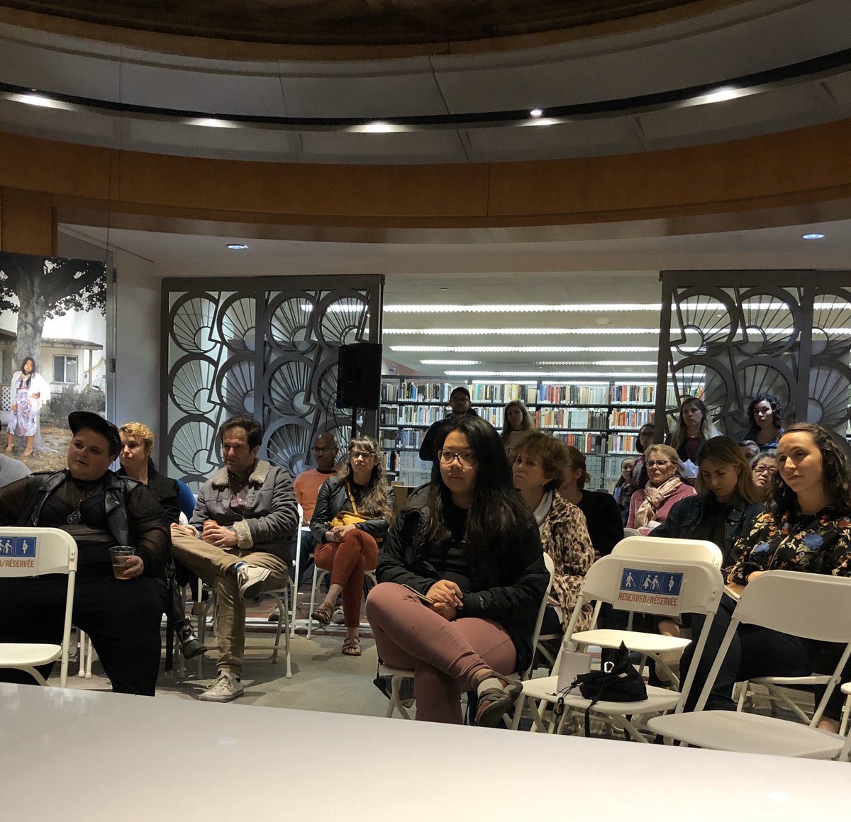 Group of people sitting in rows of chairs for a panel