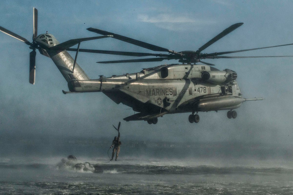 A Marine jumps from a helicopter into the water during a training exercise. 