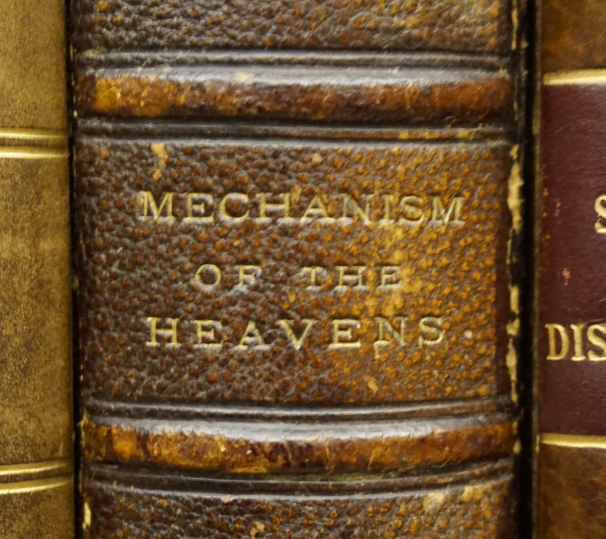 The spine of Mary Somerville's book with the title Mechanism of the Heavens stamped in gilt.