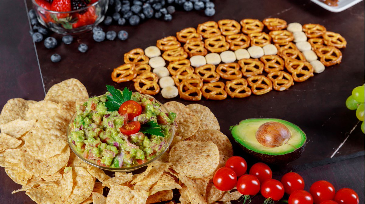 Photo of some healthy snack options for a Super Bowl party, including whole-grain chips and guacamole and fruit.
