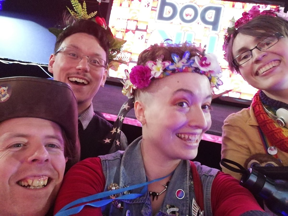 Sam, Jason, Ellie and Robbie smiling in front of a screen reading poduk, just after their live show