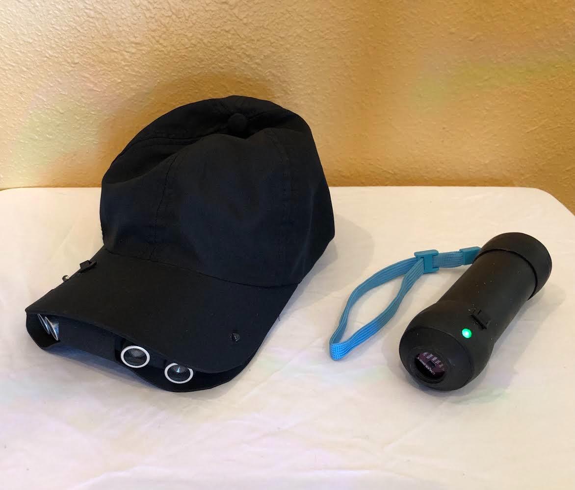 Black hat with sensors on a table next to a sensor wand.