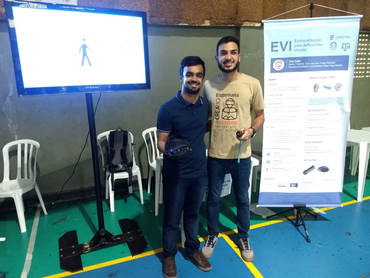 Team members stand holding their prototype after presenting to a group in Brazil.