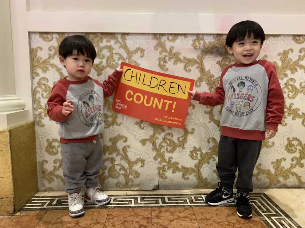 A photo of two little kids holding a sign that says children count!