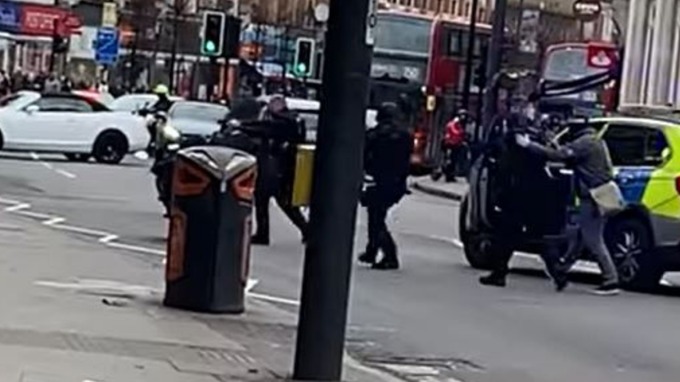 Armed police in civilian clothes run towards an attack
