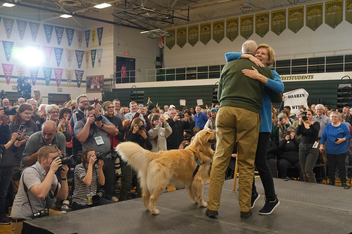 Elizabeth Warren hugs her husband, Bruce, while her dog Bailey stands nearby.