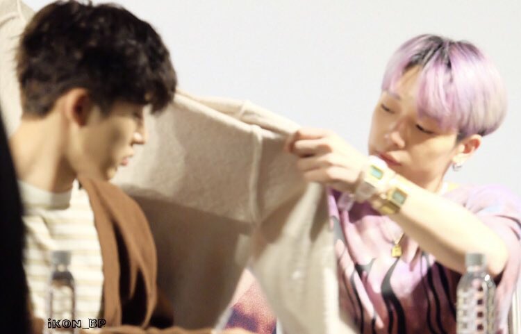 Jiwon putting a jacket on Hanbin 