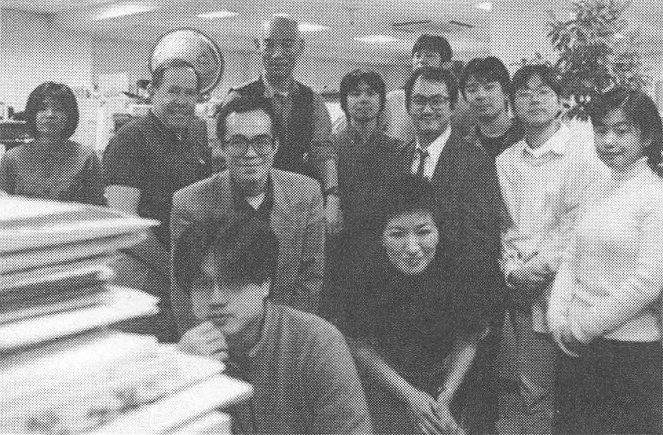 A photo of Yoshiyuki Tomino, Syd Mead, and other staff members at the studio (April 9th 1999 - episode 1 air date).