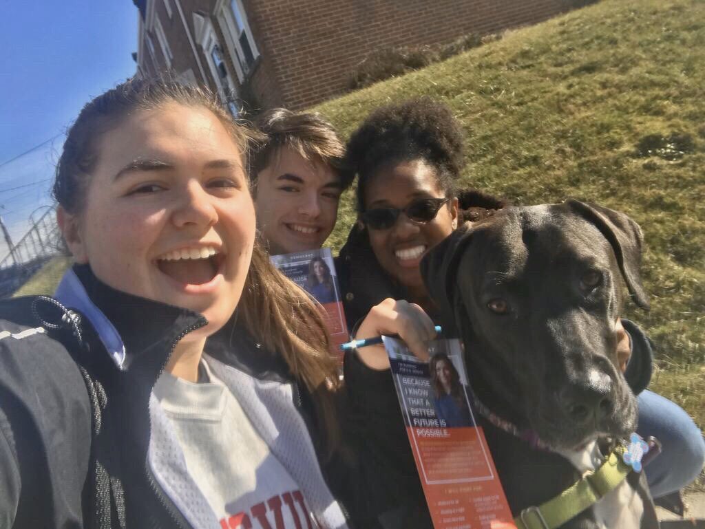 Three volunteer canvassers and a dog taking a selfie