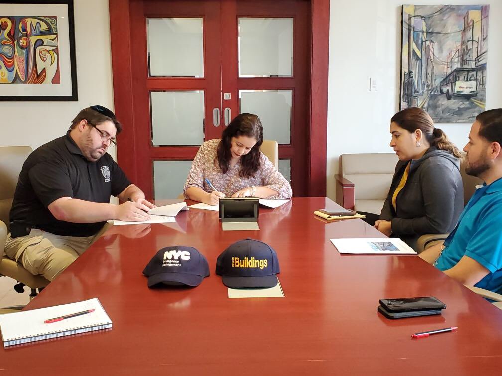 NYC Emergency Management and NYC Department of Buildings staff sitting at a table with staff from City of Aguadilla in Puerto Rico.‬