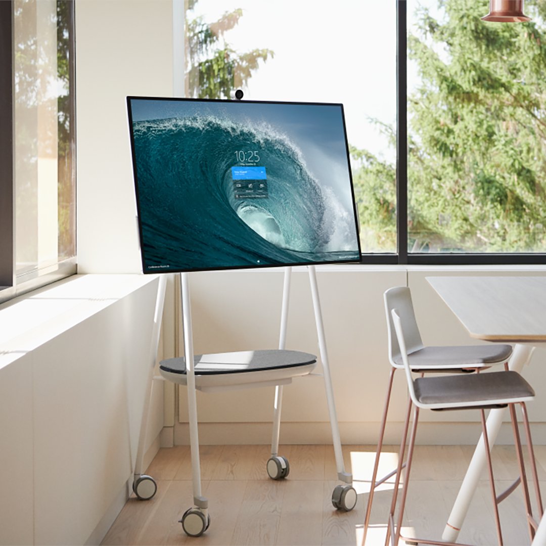 A Surface Hub 2S and stand in a beautiful modern office environment. 