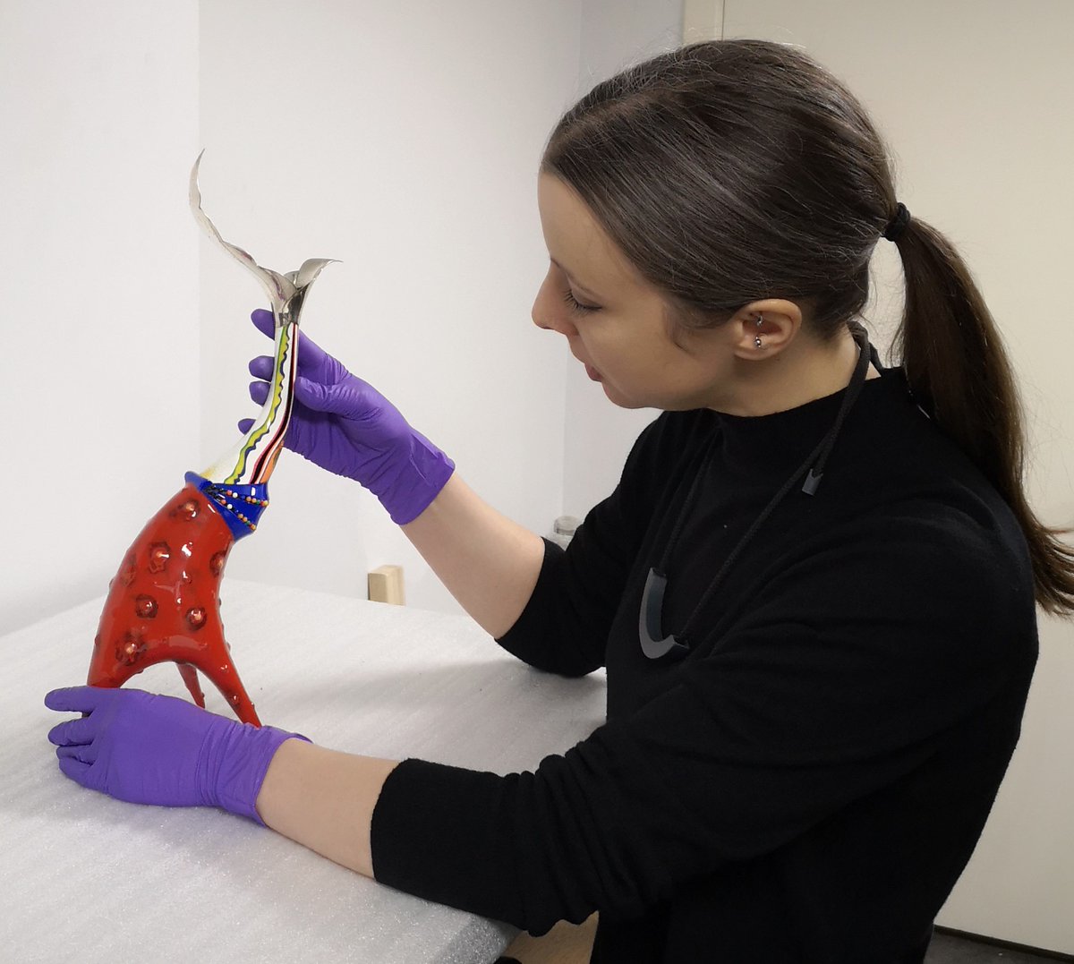 nspecting Peter Chang’s candle holder in store (A.1995.62)