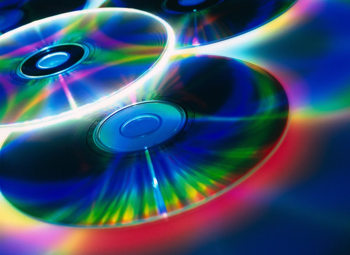 CDs with multi-coloured bands of light bouncing off their reflective surfaces.