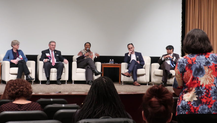 Five people sitting on stage answering a standing audience member