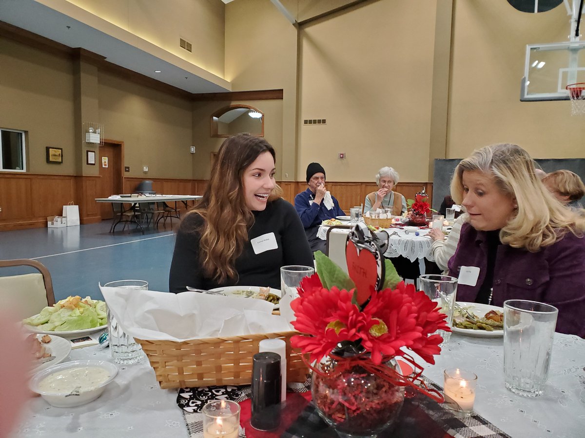 Emma Wyllys, student intern, and Beth Klug. Executive Director, chat during dinner. Outstanding meal cooked and served by the Knights of Columbus and St. Thomas More youth.