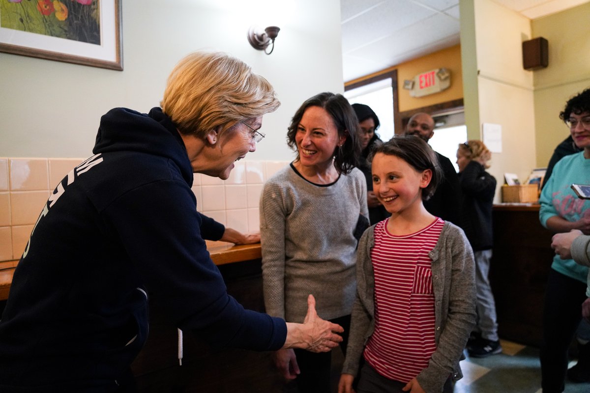 Elizabeth Warren says hello to a young girl.
