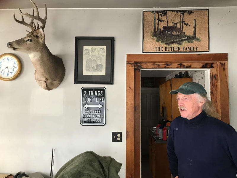 A person stands in a door frame below a sign reading "The Butler Family"