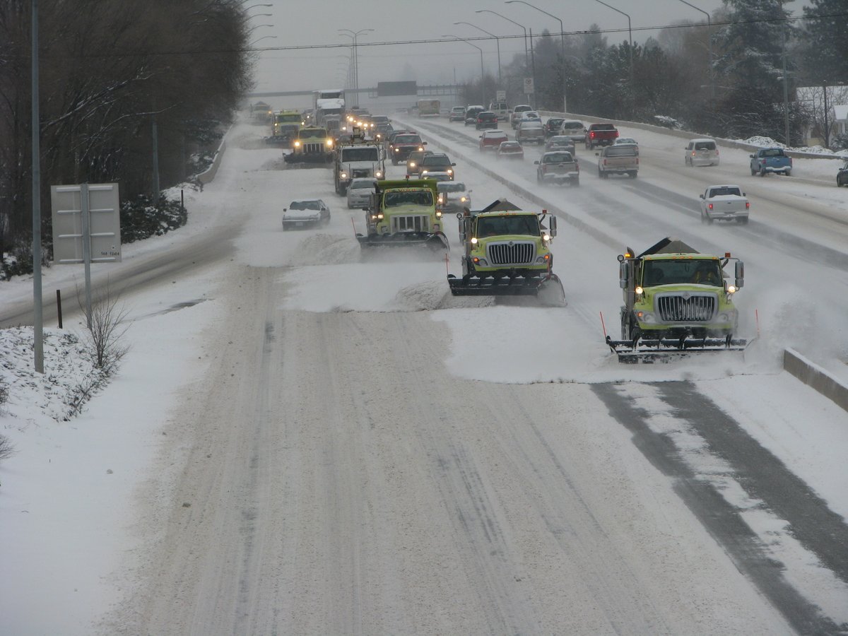 Picture of 6 plow trucks clearing I-90 in Spokane from 2011.