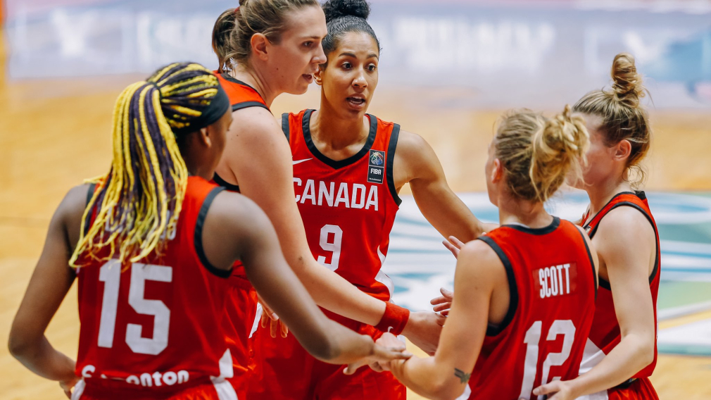 five team canada basketball players huddle