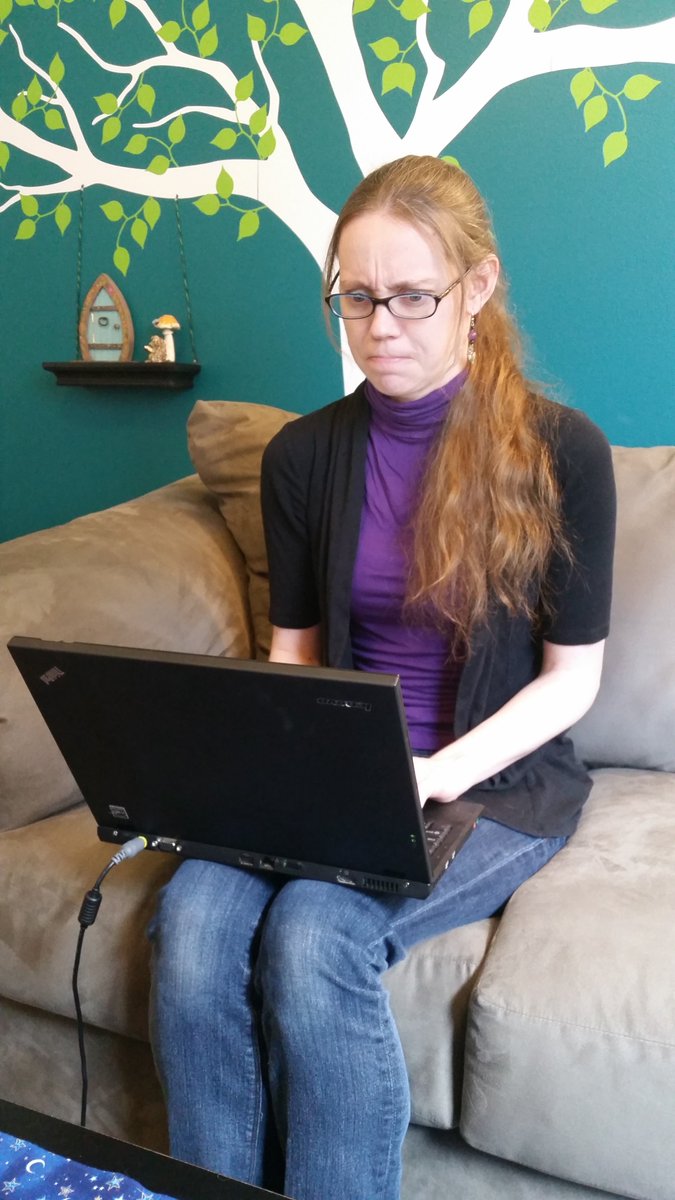 Casey at 28yo in the same purple shirt sitting in her office staring at her laptop screen like words have no meaning.