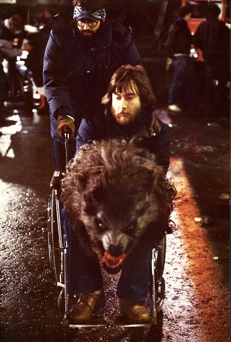 For the scenes with the werewolf running around in the street, the effects team used a wheel barrow race concept where someone was in the suit working the arms and someone else was behind them pushing. Here’s an example for just a head shot they used a wheelchair.  #AAWIL