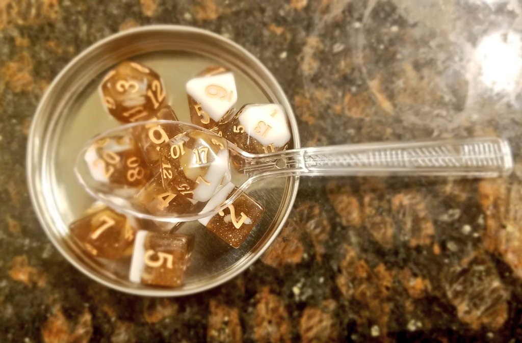 Picture of dice with d20 on a spoon.