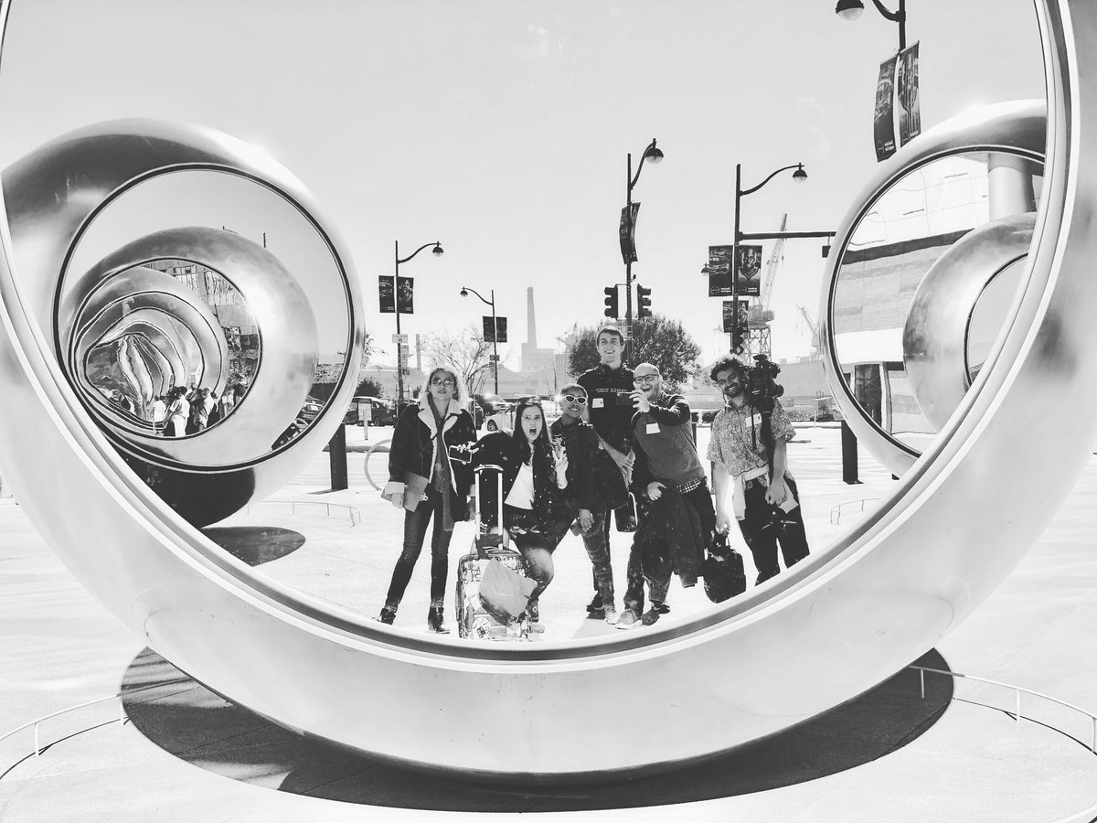 Camera crew poses in outdoor mirror
