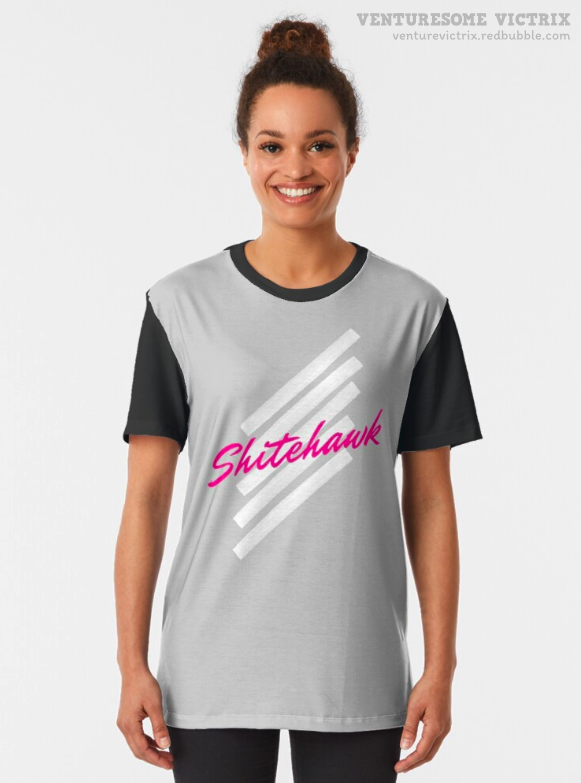 A t-shirt featuring an eighties style design on a grey background. The text, in pink, reads "Shitehawk" on top of four white diagonal brushstrokes. 