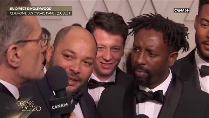 PremiereFR's tweet photo. Ladj Ly : "on est très fier de représenter la France, c'est une aventure énorme". Les Misérables fait face à l'ogre Parasite pour l'Oscar du meilleur film en langue étrangère, mais c'est déjà beau d'être aux #Oscars https://t.co/AMErKPkghc