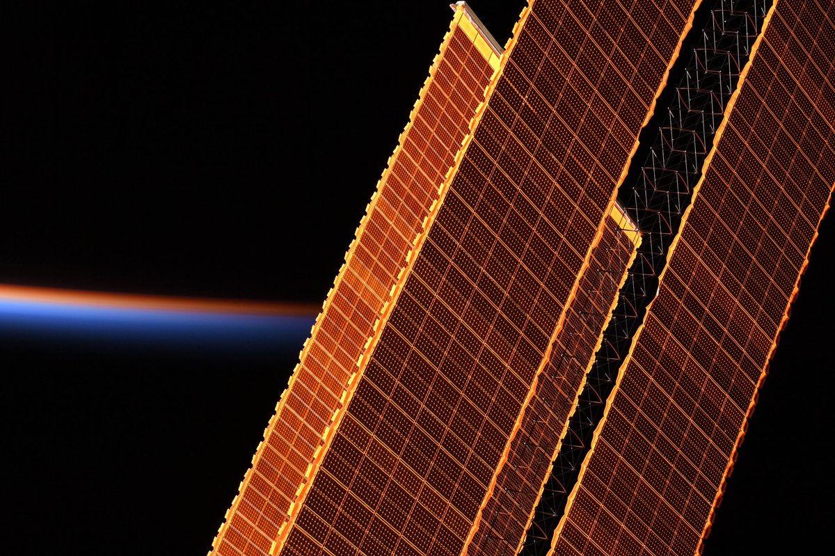 Astro_Jessica's tweet image. I love when the sunlight hits the @Space_Station solar arrays with this golden shimmer – even better against the multihued backdrop of sunset.