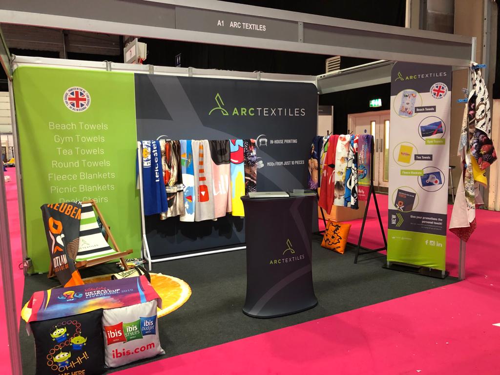 ArcTextiles's tweet image. We're all set up and ready to go for our first day at @MerchWorld_UK! Come and chat to us at Stand A1 to find out more about our range of 7 day printed beach towels, fleece blankets, tea towels and more!  
We look forward to seeing you.